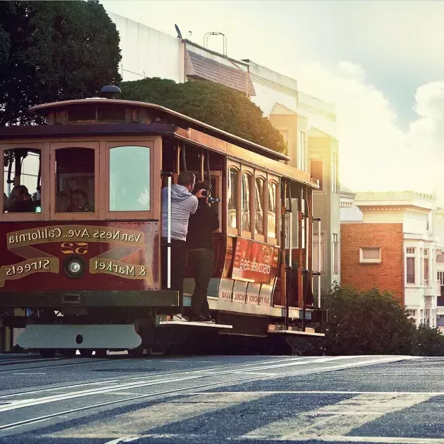 A cable car rounds a hill in 贝博体彩app with passengers looking out the window.